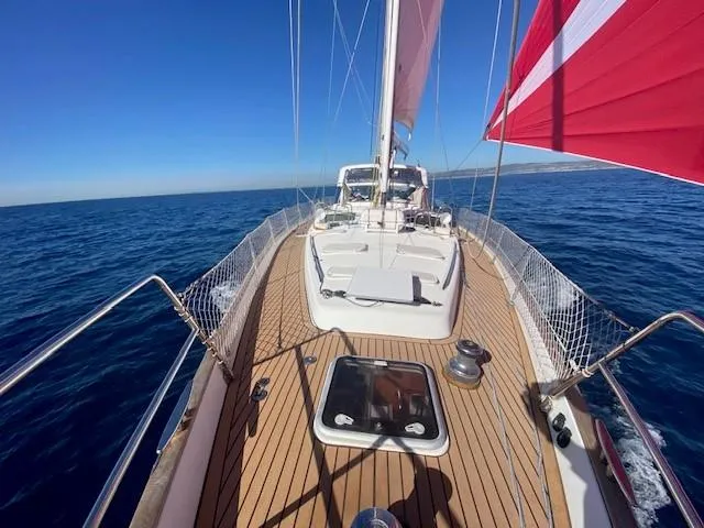 2.0 Impulsive Yacht Photos Pics Beneteau 57 sailboat deck, 2005 model, sailing on open sea with clear blue skies.