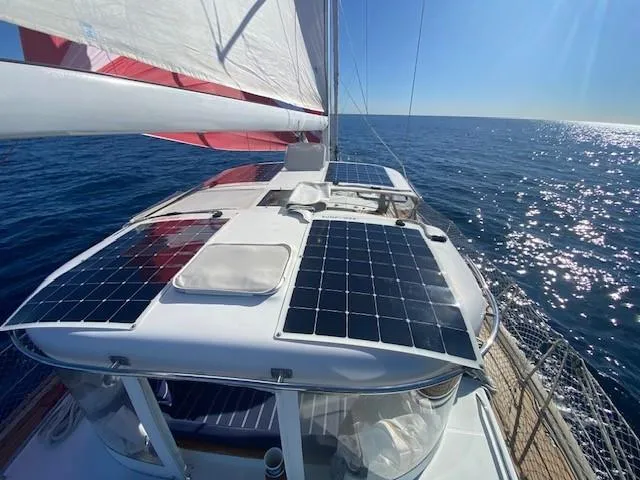 2.0 Impulsive Yacht Photos Pics Sailing yacht Beneteau 57 (2005) with solar panels on deck, cruising in open sea.