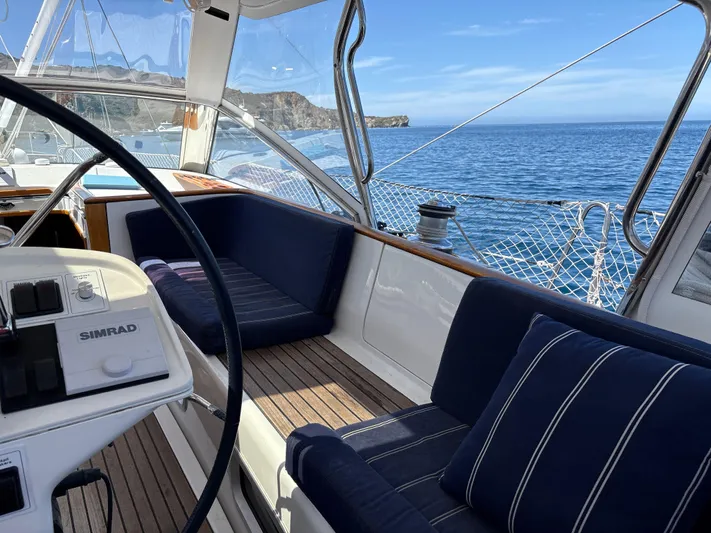 2.0 Impulsive Yacht Photos Pics Cockpit of 2005 Beneteau 57 yacht with ocean view and blue seating.