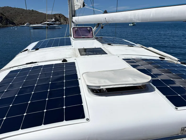 2.0 Impulsive Yacht Photos Pics Sailboat deck with solar panels, Beneteau 57, 2005 model, anchored in a scenic bay.