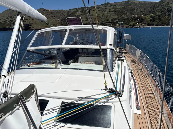 2.0 Impulsive Yacht Photos Pics Beneteau 57 sailboat, 2005 model, docked in scenic bay with clear blue water.