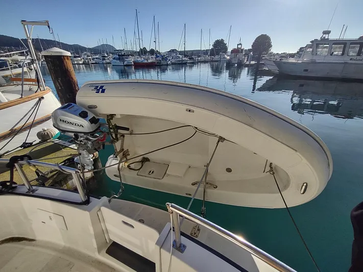 Santosha Yacht Photos Pics Nordic Tug 32 (2006) with dinghy and Honda motor in a marina setting.