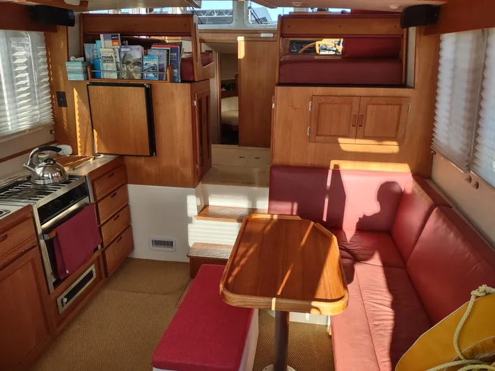 Santosha Yacht Photos Pics Interior of a 2006 Nordic Tug 32, featuring a cozy dining area and compact kitchen.