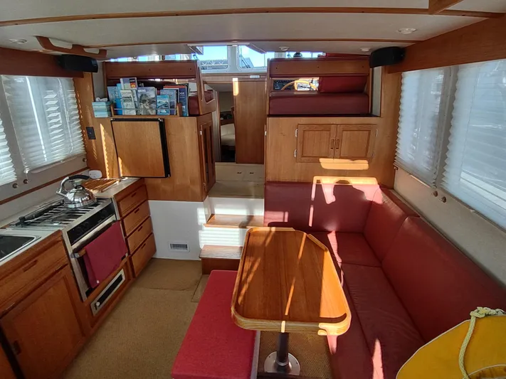 Santosha Yacht Photos Pics Interior of a 2006 Nordic Tug 32, featuring a cozy dining area and compact kitchen.