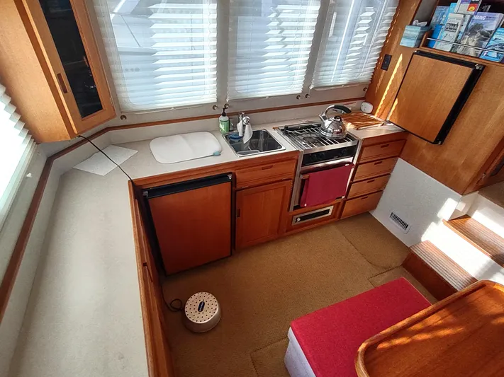 Santosha Yacht Photos Pics 2006 Nordic Tug 32 galley with stove, sink, and wooden cabinetry.