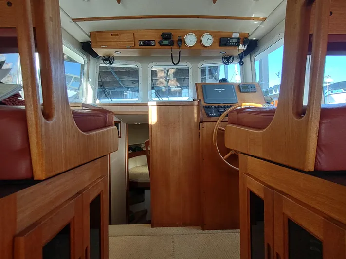 Santosha Yacht Photos Pics Interior of 2006 Nordic Tug 32, featuring wooden helm and seating.