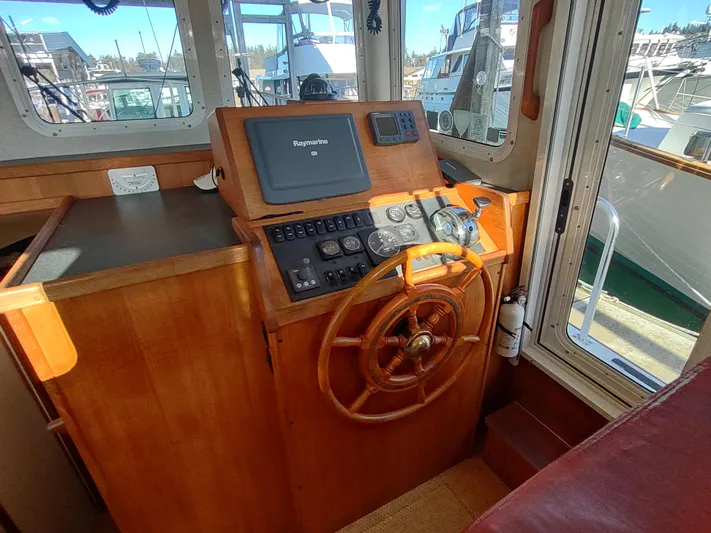 Santosha Yacht Photos Pics 2006 Nordic Tug 32 helm with wooden wheel and navigation equipment.
