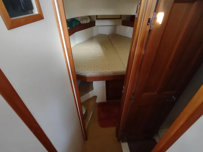 Santosha Yacht Photos Pics 2006 Nordic Tug 32 interior cabin with cozy bed and wooden accents.