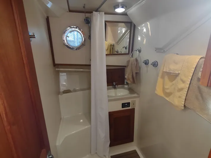 Santosha Yacht Photos Pics Bathroom interior of 2006 Nordic Tug 32 with shower, sink, and porthole window.