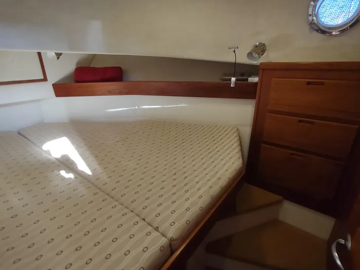 Santosha Yacht Photos Pics Cozy cabin interior of 2006 Nordic Tug 32 with bed and wooden storage.