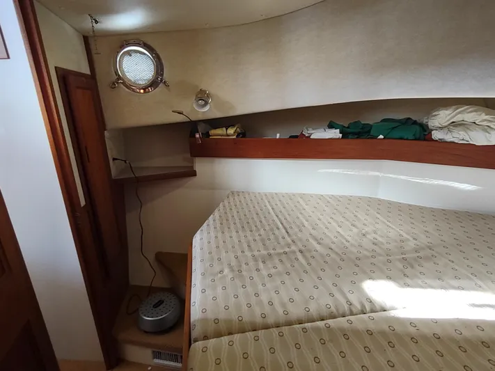 Santosha Yacht Photos Pics Cozy cabin interior of 2006 Nordic Tug 32 with bed and porthole.