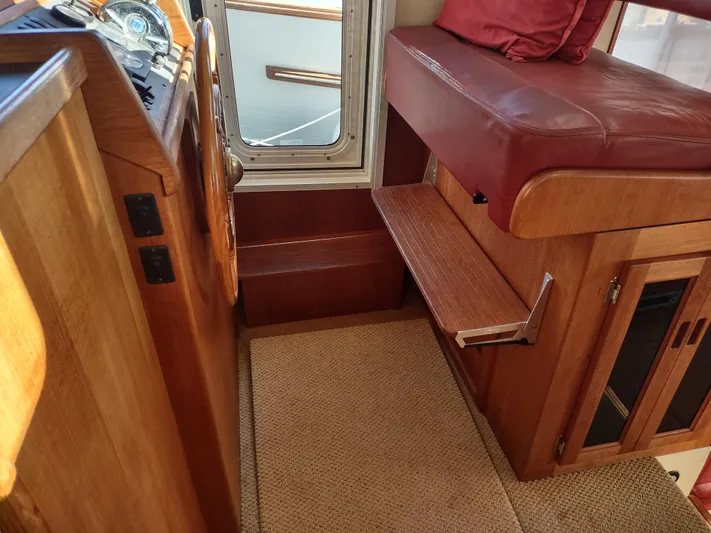 Santosha Yacht Photos Pics Interior of a 2006 Nordic Tug 32, featuring wooden cabinetry and a cushioned seat.