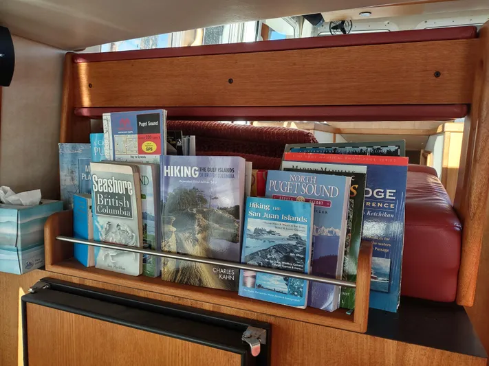 Santosha Yacht Photos Pics Bookshelf on 2006 Nordic Tug 32 with hiking and travel guides.