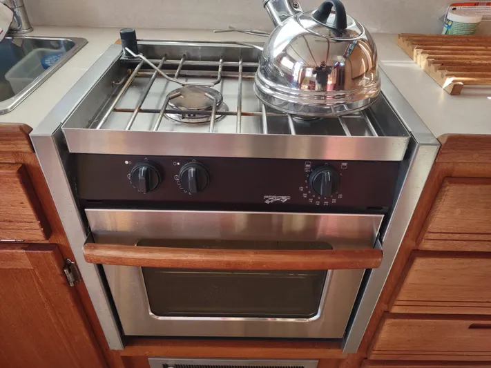 Santosha Yacht Photos Pics Stainless steel stove with kettle in a 2006 Nordic Tug 32 boat kitchen.