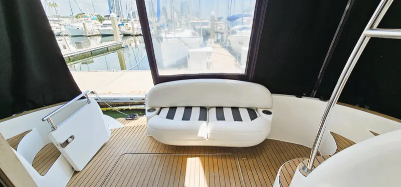  Yacht Photos Pics 2007 Meridian 341 Sedan yacht interior with white seating and wooden flooring at a marina.