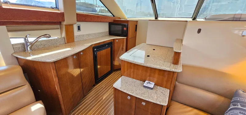  Yacht Photos Pics 2007 Meridian 341 Sedan interior with wood cabinetry, kitchenette, and seating area.