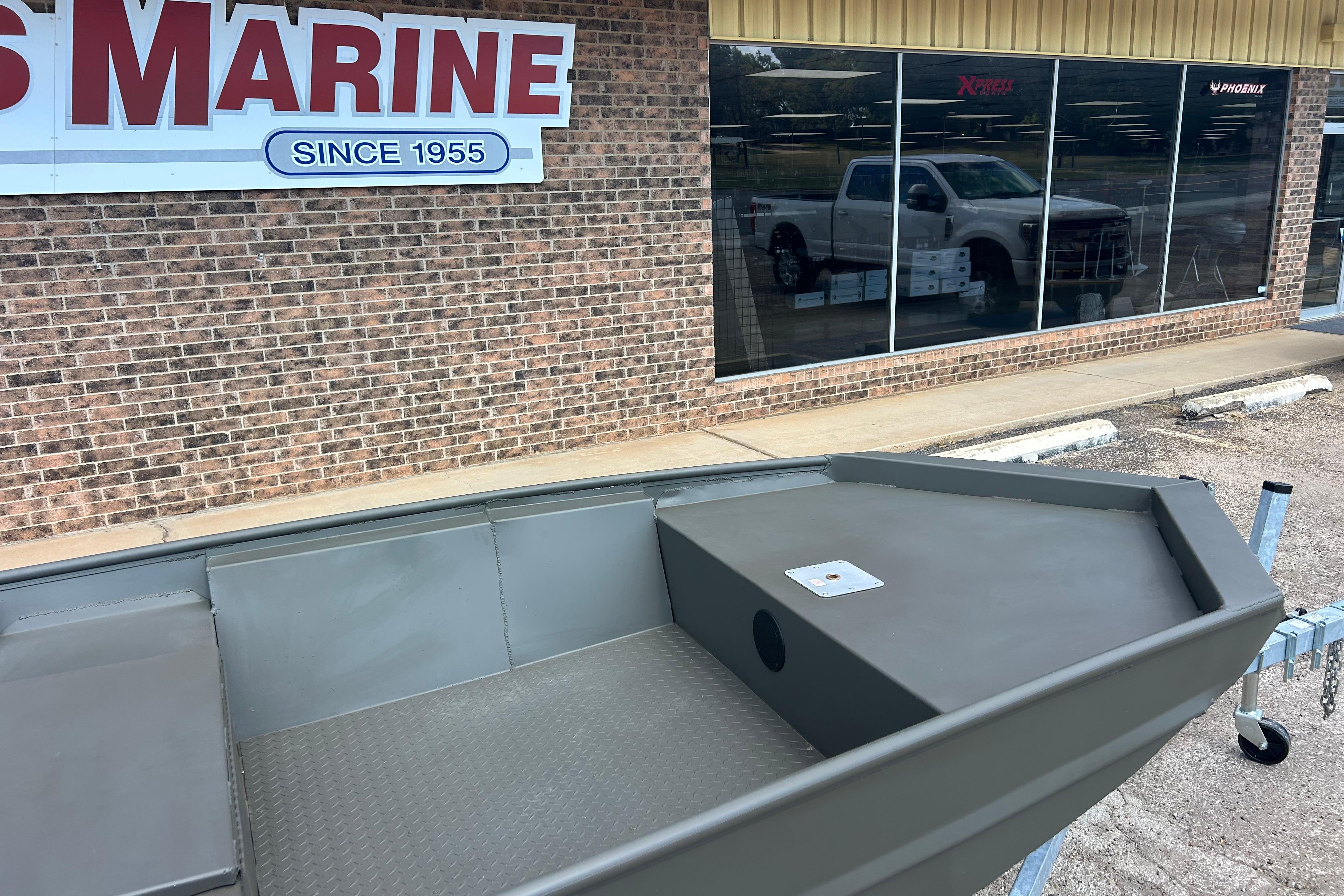 2025 WeldBilt 1648 boat displayed outside a marine store with a brick facade.