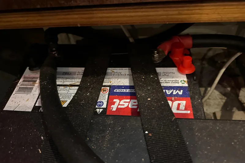  Yacht Photos Pics Battery compartment of a 2004 Beneteau 50 sailboat, featuring a secured marine battery.