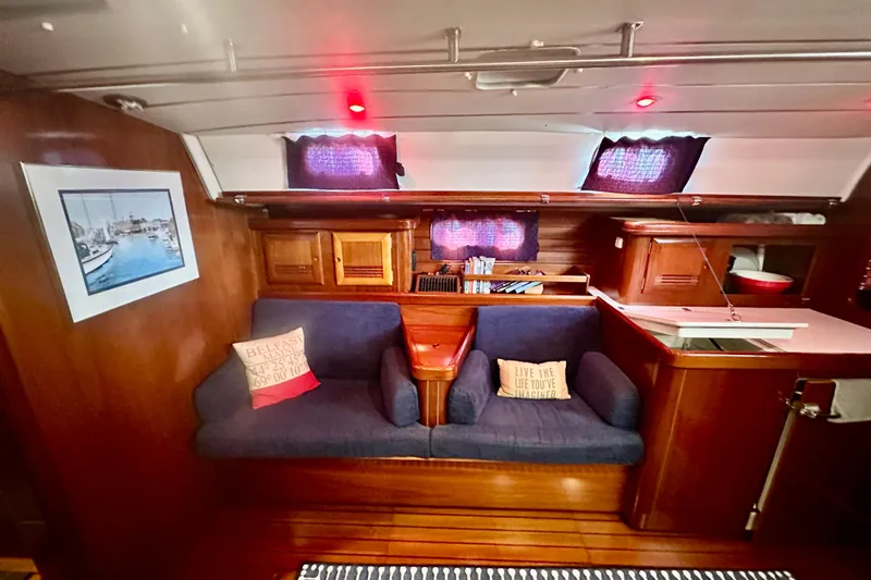  Yacht Photos Pics Cozy interior of 2004 Beneteau 50 yacht with blue seating and nautical decor.
