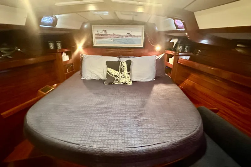  Yacht Photos Pics Cozy cabin interior of a 2004 Beneteau 50 yacht with a comfortable bed and nautical decor.