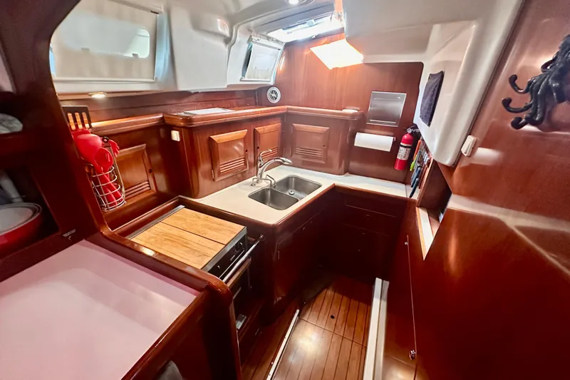  Yacht Photos Pics Luxurious 2004 Beneteau 50 yacht interior kitchen with wood finish and modern amenities.