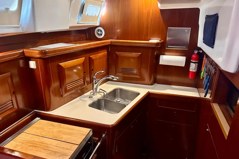 Yacht Photos Pics Luxurious 2004 Beneteau 50 yacht kitchen with wooden cabinetry and modern amenities.