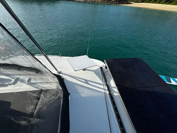 Primrose Yacht Photos Pics 2023 Lagoon 46 yacht deck overlooking serene water and sandy shore.