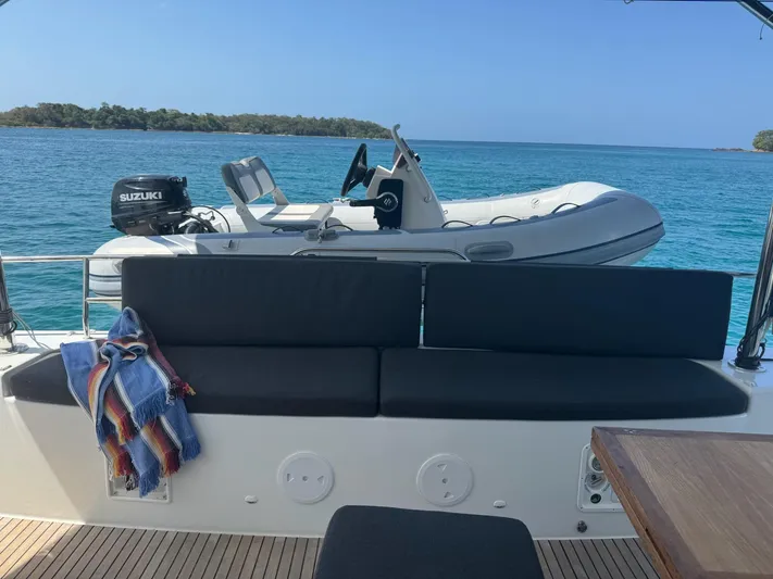 Primrose Yacht Photos Pics 2023 Lagoon 46 yacht with a tender boat on turquoise water.