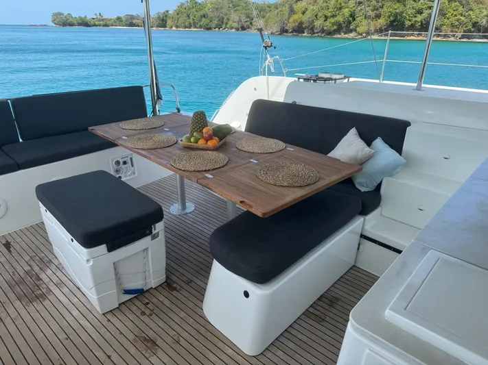 Primrose Yacht Photos Pics Luxurious Lagoon 46 yacht deck with dining area, 2023 model, overlooking serene blue waters.