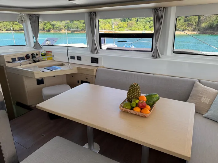 Primrose Yacht Photos Pics Interior of 2023 Lagoon 46 catamaran with dining area and fruit basket.