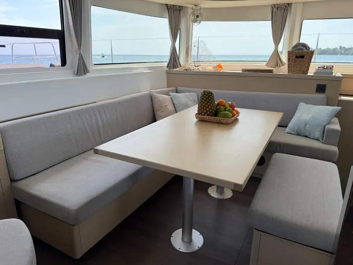 Primrose Yacht Photos Pics Interior of 2023 Lagoon 46 catamaran with dining area and ocean view.