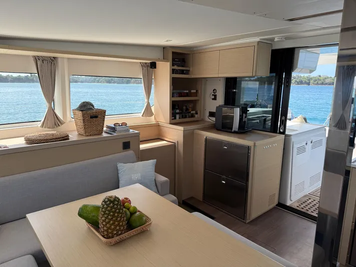 Primrose Yacht Photos Pics Modern interior of 2023 Lagoon 46 yacht with kitchen and dining area, overlooking the sea.