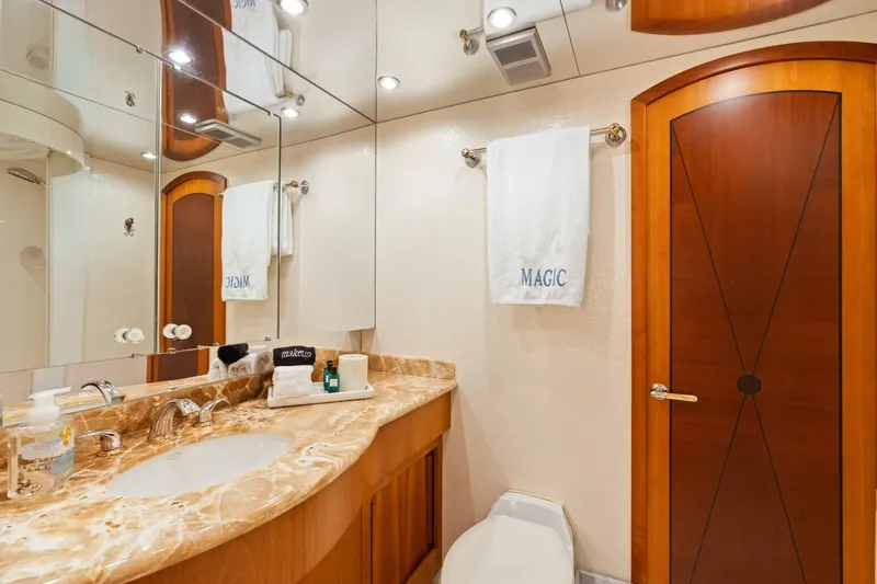 Magic Yacht Photos Pics Luxurious bathroom in 2005 Hatteras 100 Motor Yacht with marble countertop and wooden accents.