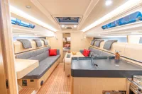 Luxurious interior of 2023 Dehler 34 yacht with modern seating and kitchen area.