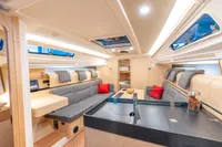 Luxurious interior of 2023 Dehler 34 yacht with modern seating and sleek kitchen area.