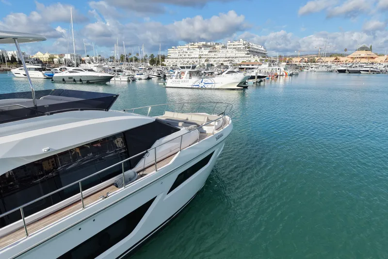 Yacht Photos Pics 2023 Ferretti Yachts 580 docked in a marina with other luxury boats.