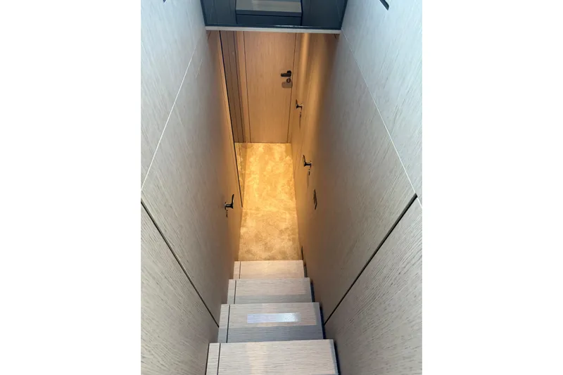  Yacht Photos Pics Staircase inside 2023 Ferretti Yachts 580, featuring modern wood paneling and soft lighting.