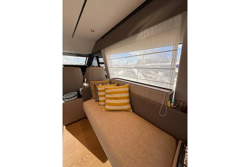  Yacht Photos Pics Luxurious interior of 2023 Ferretti Yachts 580 with cozy seating and striped cushions.