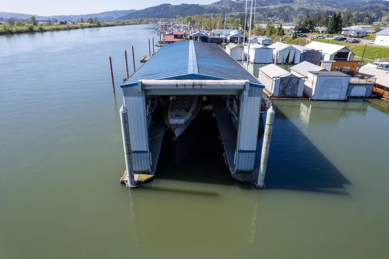  Yacht Photos Pics Aerial view of a 1985 Custom Larson Boathouse on a serene river.