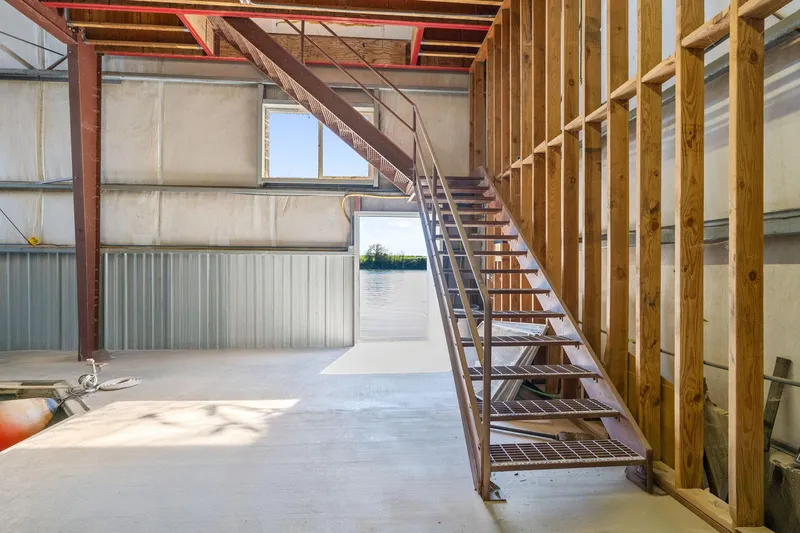  Yacht Photos Pics Industrial interior of 1985 Custom Larson Boathouse with metal staircase and wooden beams.