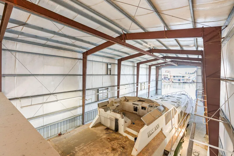  Yacht Photos Pics 1985 Custom Larson Boathouse interior with large boat docked inside.