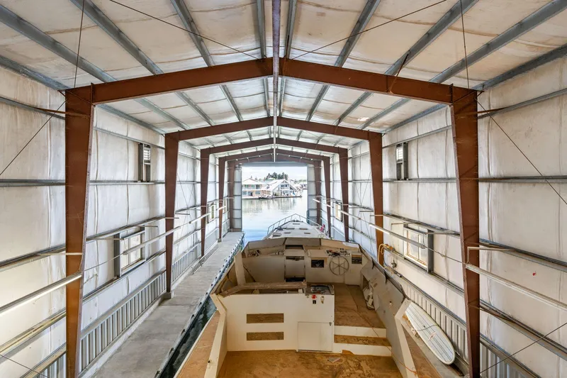  Yacht Photos Pics Interior view of a 1985 Custom Larson Boathouse with a boat docked inside.