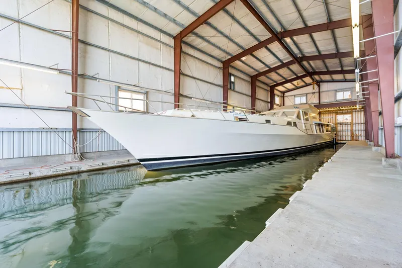  Yacht Photos Pics Custom 1985 Larson Boathouse with large boat docked inside spacious indoor facility.