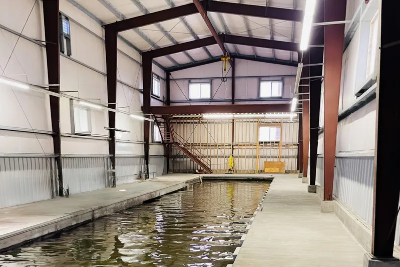  Yacht Photos Pics Spacious 1985 Custom Larson Boathouse interior with water channel and metal structure.