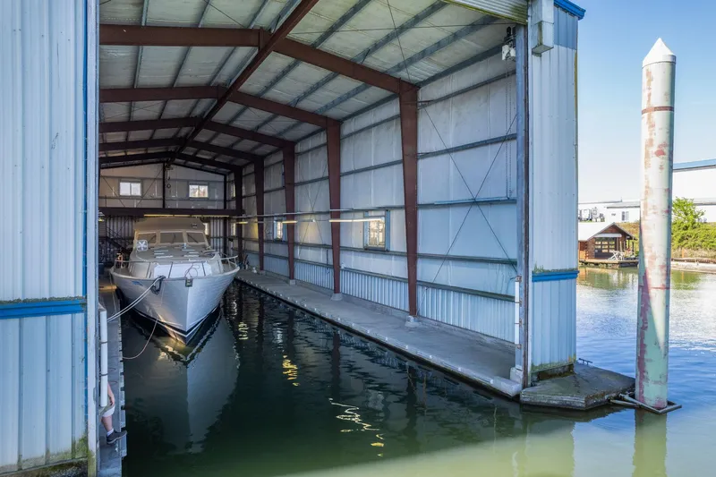  Yacht Photos Pics Custom 1985 Larson Boathouse with docked boat in sheltered marina setting.