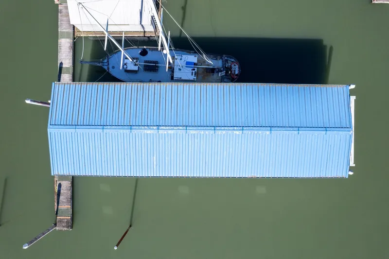  Yacht Photos Pics Aerial view of 1985 Custom Larson Boathouse with sailboat docked underneath.