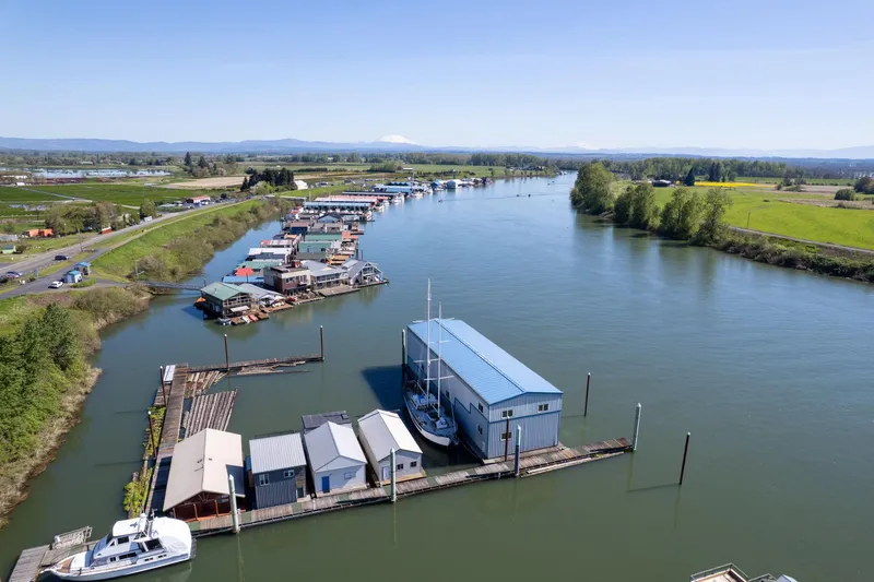  Yacht Photos Pics Aerial view of 1985 Custom Larson Boathouse on a serene river with surrounding greenery.