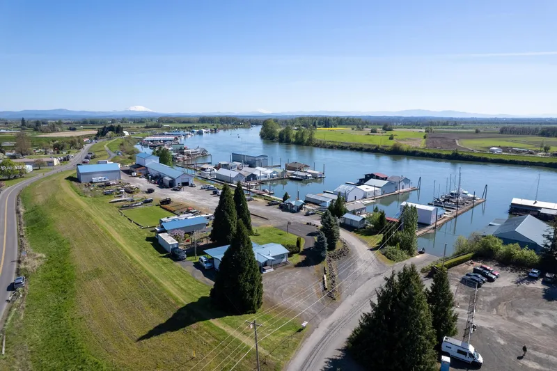  Yacht Photos Pics Aerial view of Larson Boathouse, 1985, by a scenic river with surrounding greenery.