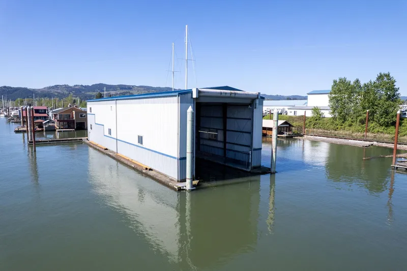  Yacht Photos Pics Custom 1985 Larson Boathouse floating on calm water under clear blue sky.