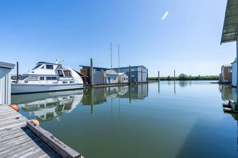  Yacht Photos Pics Calm marina view with a Custom 1985 Larson Boathouse and docked yacht.